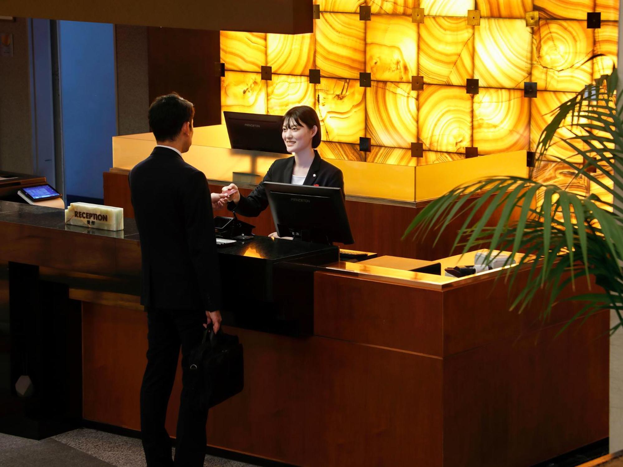 Premier Hotel -Tsubaki- Сапоро Екстериор снимка A hotel receptionist at work